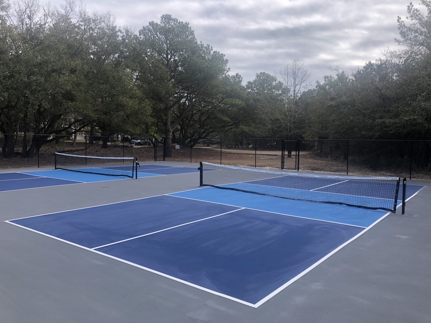 Two blue pickleball courts with nets at Sea Oats Park in Southern Shores